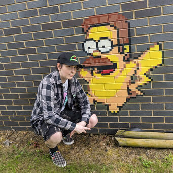 Picture of Jay A photo of Jay posing next to some amusing graffiti of a Pikachu with Ned Flanders face.